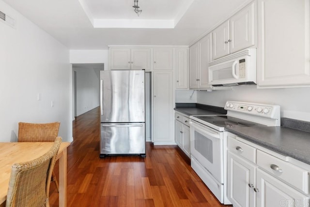 8004 Caminito Gianna, La Jolla, CA 92037 - kitchen featuring white appliances, a tray ceiling, dark countertops, and white cabinetry