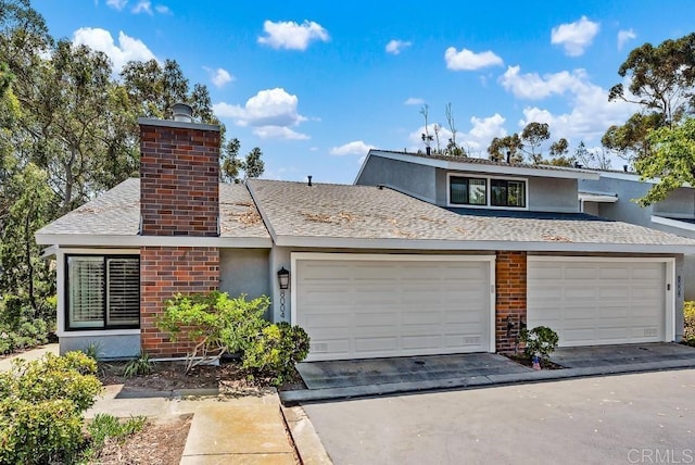 8004 Caminito Gianna, La Jolla, CA 92037 - view of front facade with stucco siding, a chimney, roof with shingles, and brick siding