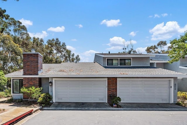 8004 Caminito Gianna, La Jolla, CA 92037 - view of front facade with stucco siding, a chimney, roof with shingles, and driveway