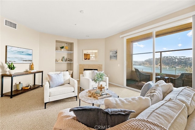 4025 Canario St Unit 142, Carlsbad, CA 92008 - living room with light carpet, built in features, a tiled fireplace, and a water view