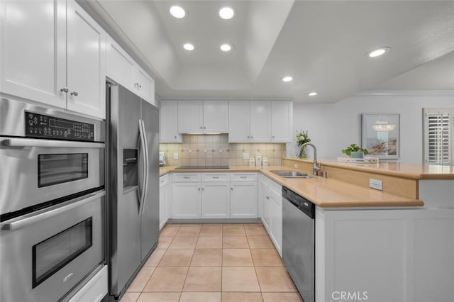 1201 S Catalina Ave Unit 3A, Redondo Beach, CA 90277 - kitchen with appliances with stainless steel finishes, white cabinetry, a peninsula, decorative backsplash, and recessed lighting