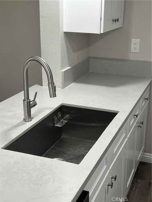 1025 N Tippecanoe Ave Unit 132, San Bernardino, CA 92410 - kitchen view of dark wood-style floors, light stone counters, and white cabinets