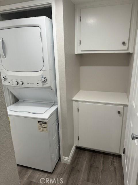 1025 N Tippecanoe Ave Unit 132, San Bernardino, CA 92410 - laundry room featuring stacked washer and clothes dryer and dark wood-style flooring