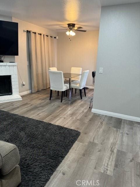 1025 N Tippecanoe Ave Unit 132, San Bernardino, CA 92410 - dining area featuring ceiling fan, wood finished floors, and a fireplace