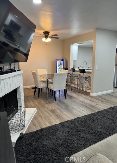 1025 N Tippecanoe Ave Unit 132, San Bernardino, CA 92410 - dining space with ceiling fan, wood finished floors, and a brick fireplace