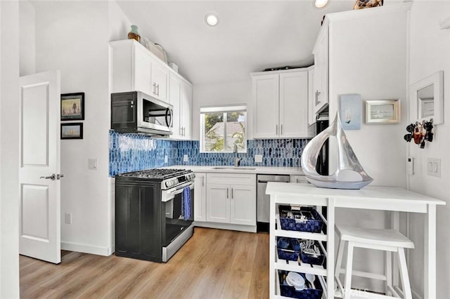 1402 E Rose Ave, Orange, CA 92867 - kitchen featuring appliances with stainless steel finishes, light wood finished floors, decorative backsplash, white cabinets, and recessed lighting