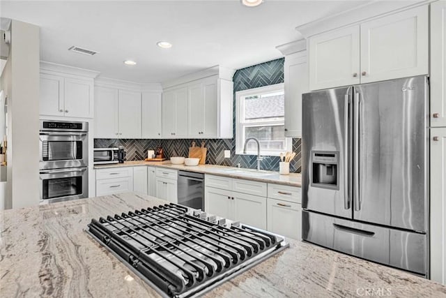 1402 E Rose Ave, Orange, CA 92867 - kitchen featuring stainless steel appliances, white cabinets, light stone counters, decorative backsplash, and recessed lighting