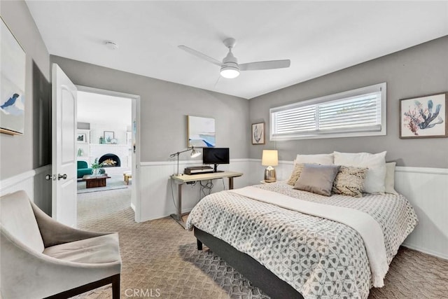 1402 E Rose Ave, Orange, CA 92867 - carpeted bedroom with a wainscoted wall, ceiling fan, and a warm lit fireplace