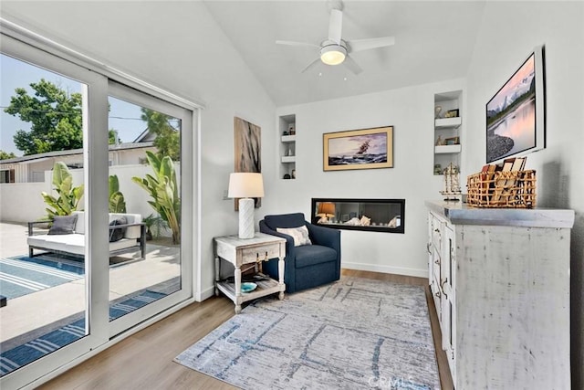 1402 E Rose Ave, Orange, CA 92867 - sitting room with built in shelves, wood finished floors, lofted ceiling, a ceiling fan, and a glass covered fireplace
