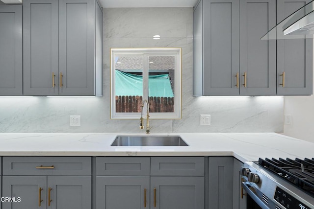 341 1st St, Fillmore, CA 93015 - kitchen featuring gray cabinetry, exhaust hood, gas range, light stone countertops, and tasteful backsplash