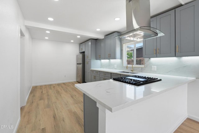 341 1st St, Fillmore, CA 93015 - kitchen with island range hood, freestanding refrigerator, gray cabinets, a peninsula, and light wood-style flooring
