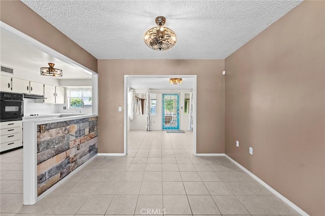 25869 Sandy Lodge Rd, Menifee, CA 92586 - entrance foyer with a textured ceiling, light tile patterned flooring, and a chandelier