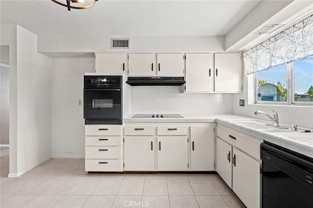 25869 Sandy Lodge Rd, Menifee, CA 92586 - kitchen with black appliances, under cabinet range hood, tile counters, tasteful backsplash, and white cabinets
