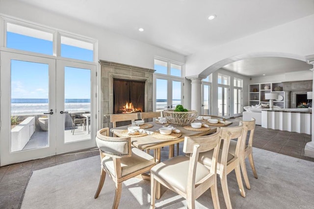 1716 Ocean Front, Del Mar, CA 92014 - dining area with a premium fireplace, french doors, arched walkways, a water view, and recessed lighting