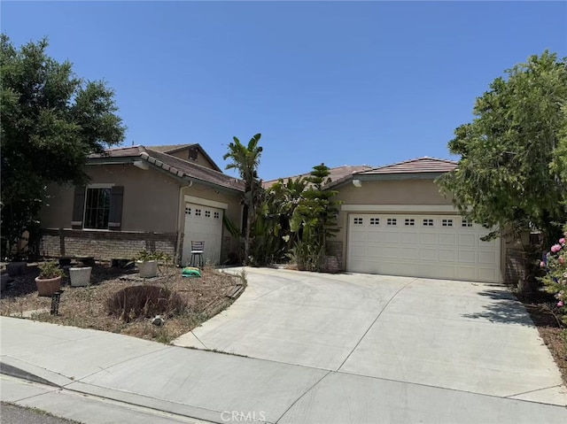 5599 Skimmer Dr, Jurupa Valley, CA 91752 - ranch-style home with stucco siding, driveway, an attached garage, brick siding, and a tile roof
