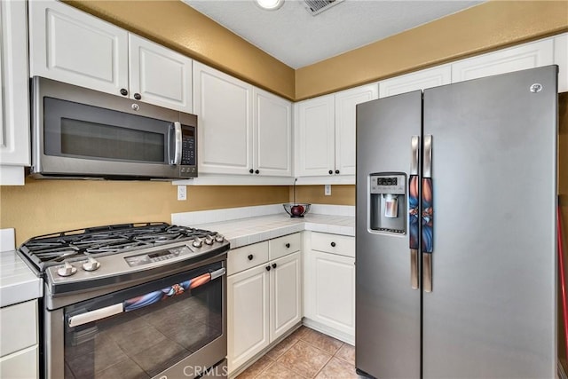 565 N Pageant Dr Unit B, Orange, CA 92869 - kitchen with stainless steel appliances, tile countertops, white cabinetry, and light tile patterned floors