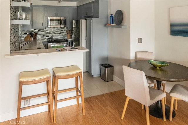 901 Ocean Ave, Santa Monica, CA 90403 - kitchen with stainless steel appliances, backsplash, open shelves, and a peninsula