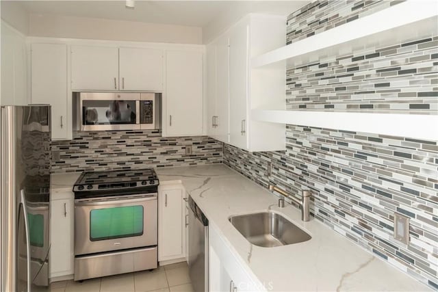 901 Ocean Ave, Santa Monica, CA 90403 - kitchen featuring appliances with stainless steel finishes, backsplash, white cabinetry, and light stone countertops