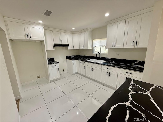 236 S 5th St, Montebello, CA 90640 - kitchen featuring recessed lighting, white cabinetry, light tile patterned floors, dark countertops, and under cabinet range hood