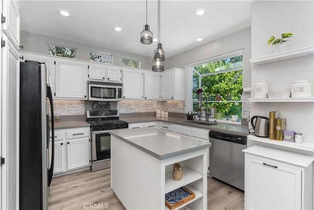 34 Key Largo, Aliso Viejo, CA 92656 - kitchen featuring appliances with stainless steel finishes, open shelves, tasteful backsplash, white cabinets, and light wood-style flooring