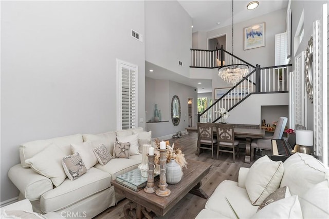 34 Key Largo, Aliso Viejo, CA 92656 - living room with stairs, wood finished floors, a towering ceiling, and a chandelier