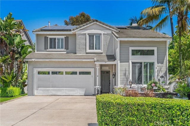 34 Key Largo, Aliso Viejo, CA 92656 - view of front of house with concrete driveway, an attached garage, roof mounted solar panels, and stucco siding