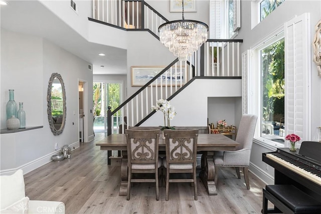 34 Key Largo, Aliso Viejo, CA 92656 - dining room featuring wood finished floors, stairs, a chandelier, plenty of natural light, and a towering ceiling