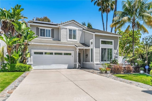 34 Key Largo, Aliso Viejo, CA 92656 - view of front facade with driveway, an attached garage, solar panels, stucco siding, and a tile roof