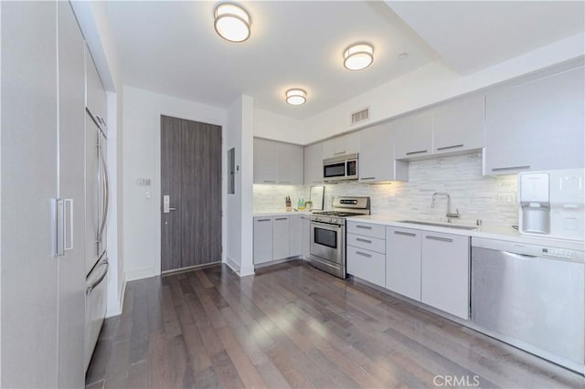 1817 Prosser Ave Unit 305, Los Angeles, CA 90025 - kitchen featuring appliances with stainless steel finishes, dark wood finished floors, tasteful backsplash, light countertops, and modern cabinets