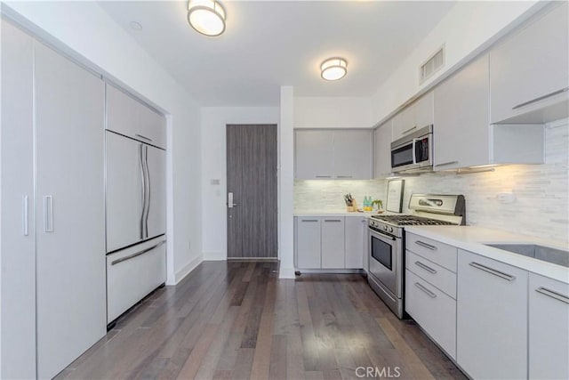 1817 Prosser Ave Unit 305, Los Angeles, CA 90025 - kitchen with stainless steel appliances, light countertops, decorative backsplash, dark wood finished floors, and white cabinetry