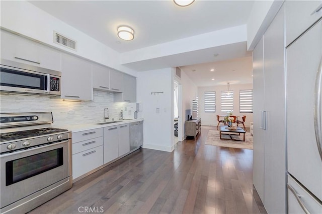1817 Prosser Ave Unit 305, Los Angeles, CA 90025 - kitchen featuring appliances with stainless steel finishes, light countertops, decorative backsplash, white cabinetry, and dark wood finished floors
