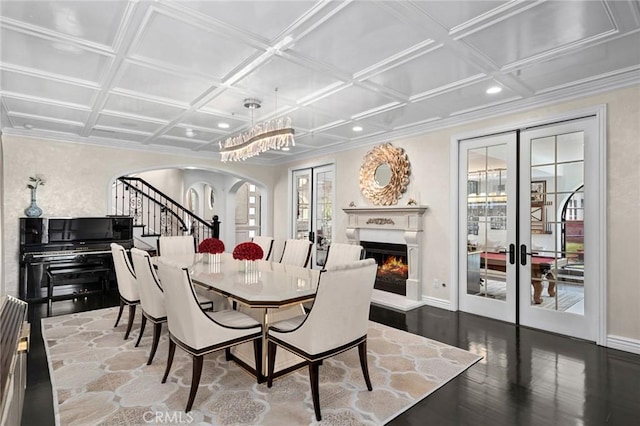 17 Lemans, Newport Coast, CA 92657 - dining area featuring arched walkways, french doors, wood finished floors, a chandelier, and stairs