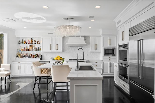 17 Lemans, Newport Coast, CA 92657 - kitchen with built in appliances, premium range hood, ornamental molding, white cabinetry, and decorative backsplash