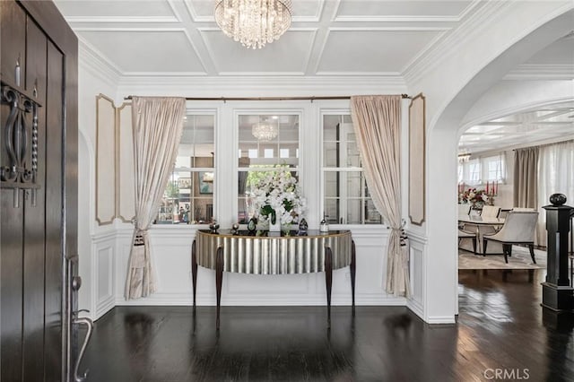 17 Lemans, Newport Coast, CA 92657 - entrance foyer with a chandelier, arched walkways, dark wood-style floors, a decorative wall, and coffered ceiling