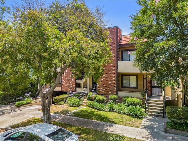1207 N Columbus Ave, Glendale, CA 91202 - view of property with stucco siding, brick siding, a tiled roof, and stairway