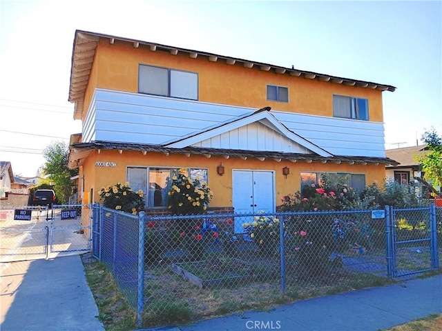 10007 Otis St, South Gate, CA 90280 - view of front of house with a gate, a fenced front yard, and stucco siding