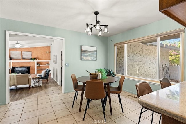 667 Morgan Dr, Chico, CA 95973 - dining room with a brick fireplace, a chandelier, light tile patterned flooring, and ceiling fan