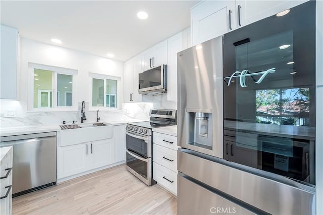 2143 Ronda Granada Unit P, Laguna Woods, CA 92637 - kitchen featuring stainless steel appliances, white cabinets, light wood finished floors, light stone counters, and recessed lighting