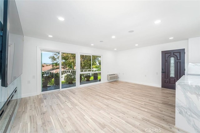 2143 Ronda Granada Unit P, Laguna Woods, CA 92637 - unfurnished living room featuring light wood-style floors, a wall unit AC, recessed lighting, and baseboard heating
