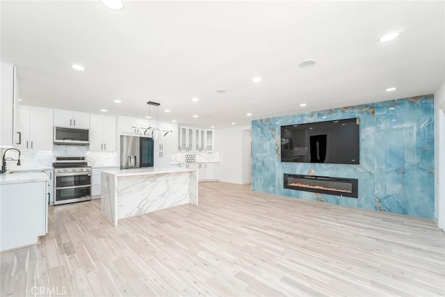 2143 Ronda Granada Unit P, Laguna Woods, CA 92637 - unfurnished living room featuring light wood-style floors, a large fireplace, and recessed lighting