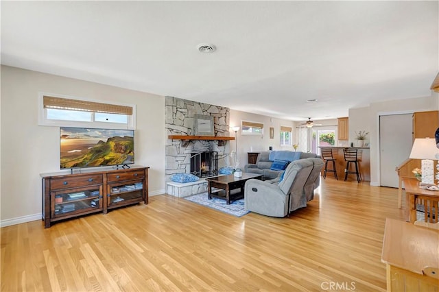 15041 Columbia Ln, Huntington Beach, CA 92647 - living area featuring light wood-style flooring, a stone fireplace, and a ceiling fan