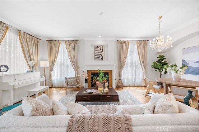 2767 Saleroso Dr, Rowland Heights, CA 91748 - living area with a chandelier, crown molding, wood finished floors, and a warm lit fireplace