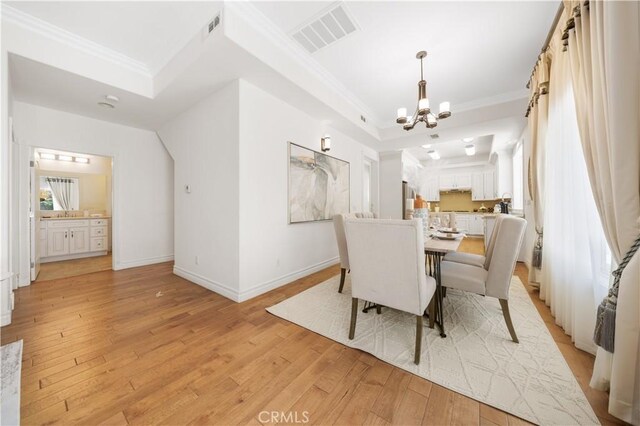 2767 Saleroso Dr, Rowland Heights, CA 91748 - dining area featuring a chandelier, light wood-type flooring, ornamental molding, and a tray ceiling