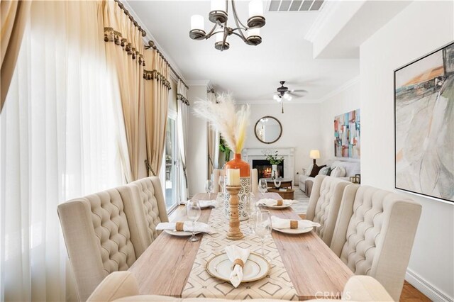 2767 Saleroso Dr, Rowland Heights, CA 91748 - dining area with a glass covered fireplace, ornamental molding, a chandelier, a ceiling fan, and light wood finished floors