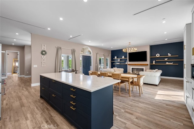 2920 Fairmount Ave, La Crescenta, CA 91214 - kitchen with light wood finished floors, a kitchen island, a glass covered fireplace, a chandelier, and recessed lighting