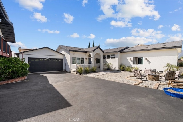 2920 Fairmount Ave, La Crescenta, CA 91214 - view of front facade with stucco siding, an outdoor fire pit, and driveway