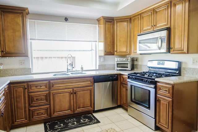 14330 Jennings Vista Way, Lakeside, CA 92040 - kitchen featuring appliances with stainless steel finishes, brown cabinetry, light tile patterned floors, and light countertops