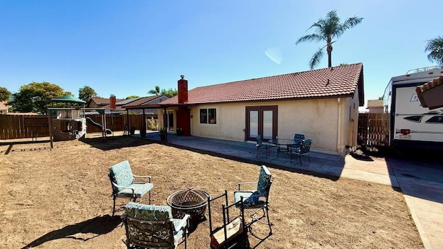 14330 Jennings Vista Way, Lakeside, CA 92040 - back of house featuring french doors, a chimney, a tiled roof, stucco siding, and a playground