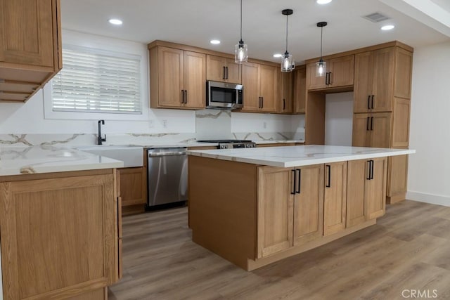 8666 Calaveras Ave, Rancho Cucamonga, CA 91730 - kitchen with stainless steel appliances, light wood-style flooring, a kitchen island, hanging light fixtures, and recessed lighting