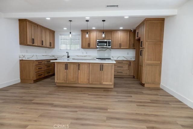 8666 Calaveras Ave, Rancho Cucamonga, CA 91730 - kitchen with stainless steel microwave, recessed lighting, light countertops, and brown cabinets